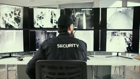 security guard monitoring cctv screens in office