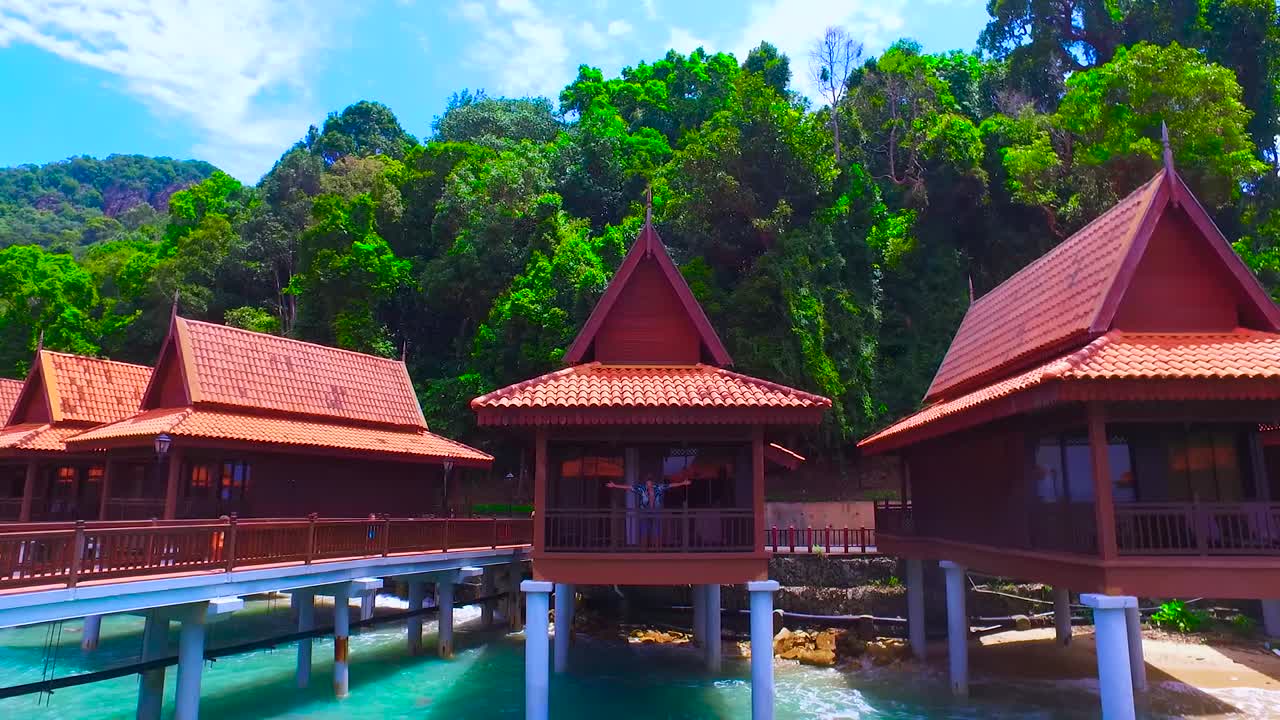 zrelaksowany mężczyzna na palach luksusowego hotelu patrzy na morze na wyspie langkawi