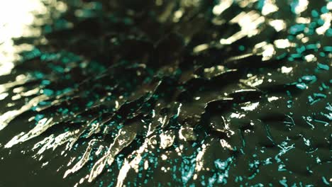 abstract macro shot of magnetic liquid ferrofluid moving motion in green light