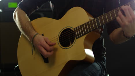hombre tocando guitarra acústica amplificada disparado en r3d