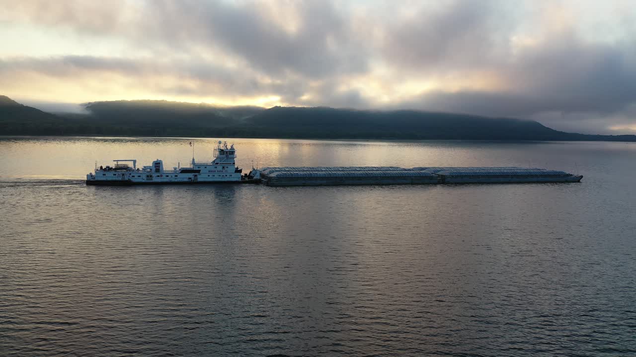 해가 뜨고 해가 지는 강에서 견인선과 배