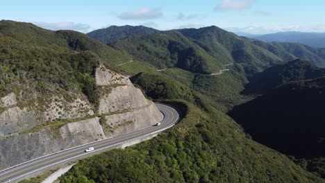 Volando-De-Lado-Para-Revelar-Y-Sinuoso-Camino-De-Montaña-Con-Autos-Circulando-Por-él