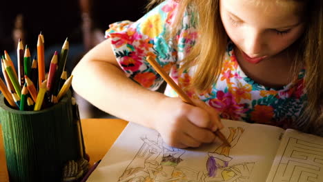 focused preschooler coloring a picture with colorful pencils