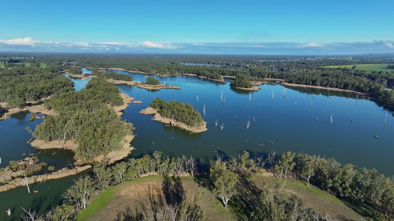 나무로 인 섬 들 과 물 의 반사물 들 은 무라 호수 에서 부나다롱 을 바라보고 있다