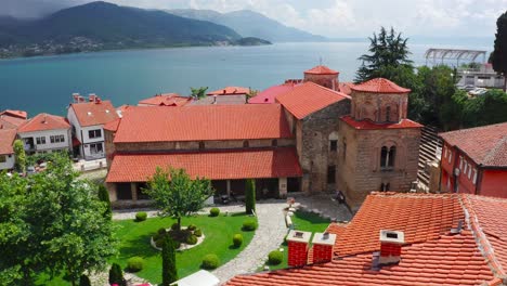 view from above of an ancient church with a calm lake in the background in ohrid, macedonia