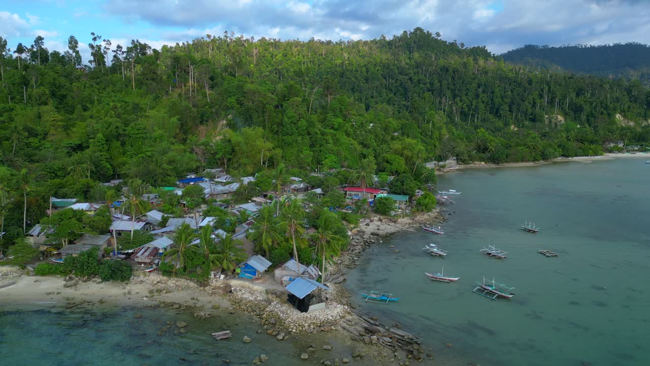 Villaggio di Port Barton, Palawan, Filippine, con barche tradizionali che riposano su acque cristalline turchesi accanto a una spiaggia sabbiosa. Incredibile vista aerea panoramica ripresa con drone dall'alto.