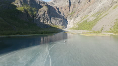 cruiser boat navigating on sea water of lyngen fjord in scandinavian alps, norway