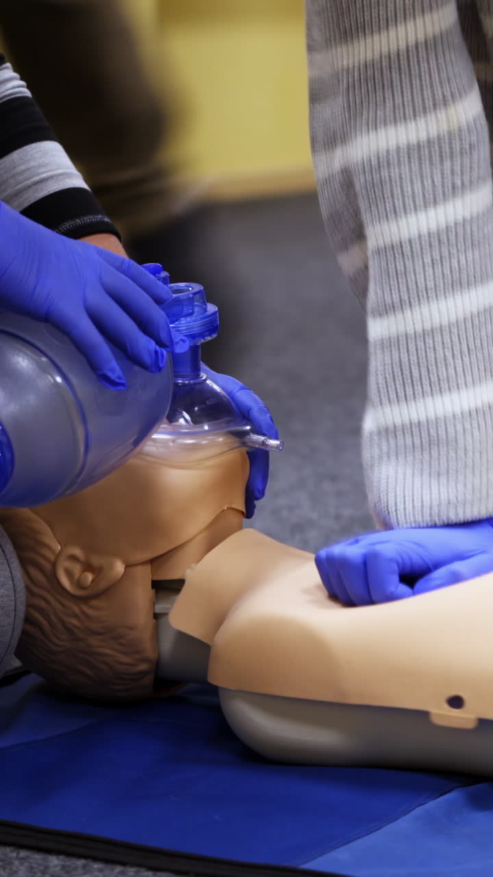 Dummies for medics used for first aid training. Experienced unrecognizible doctor gives recommendations. Oxygen mask on medical doll. Vertical video