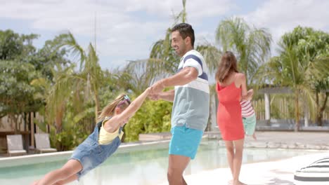 familia caucásica feliz jugando en la piscina en la casa de la playa