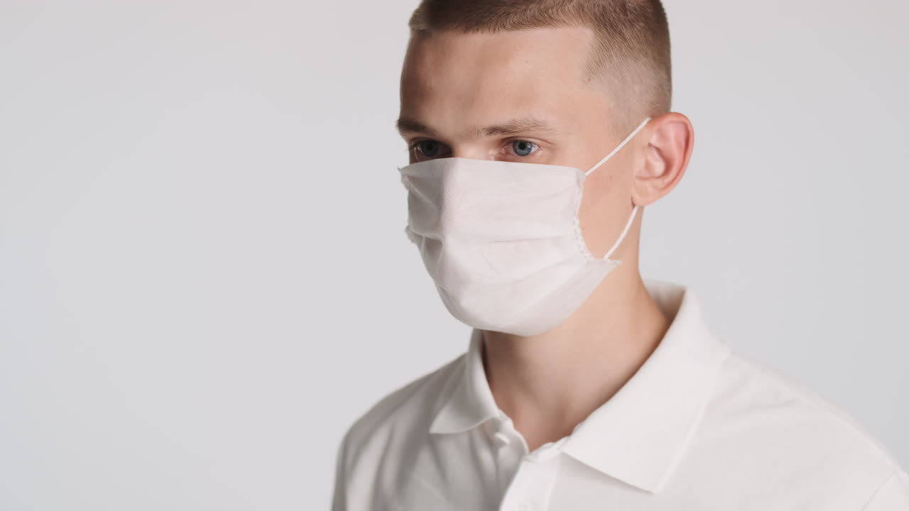 심각한 남자가  얼굴 마스크를 착용하고 있습니다.