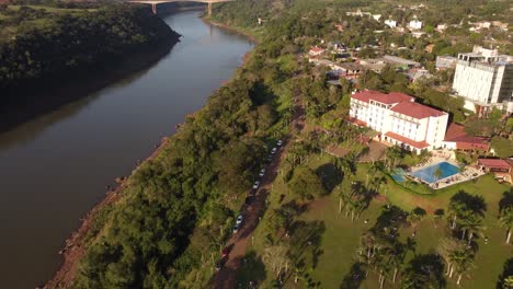 Drohnenansicht-Des-Iguazu-Flusses-Mit-Hotel-Und-Swimmingpool---Schwenkaufnahme