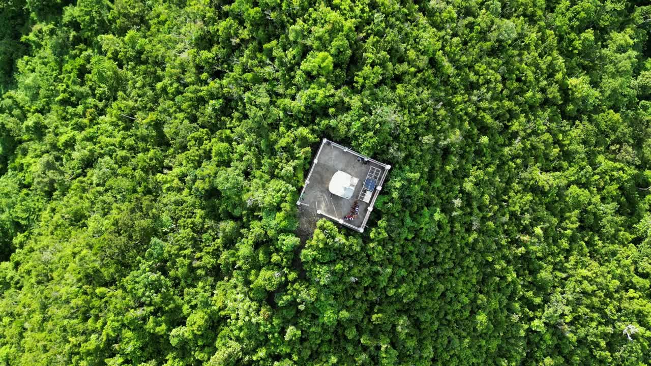 vista aérea de arriba hacia abajo de la órbita del faro blanco en lo alto de una exuberante colina cubierta de selva en la isla de catanduanes, filipinas