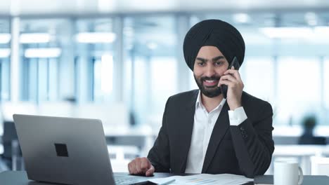 happy sikh indian businessman talking on call