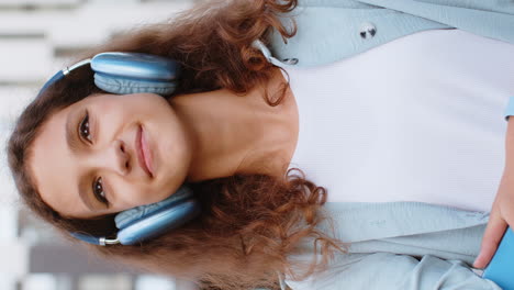 happy child girl kid in wireless headphones choosing listening music dancing outdoors city street