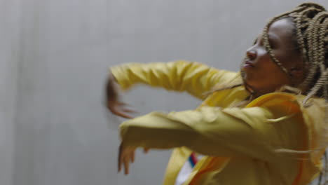 dancing woman young mixed race street dancer performing freestyle hip hop moves enjoying modern dance expression practicing in grungy warehouse wearing yellow jacket