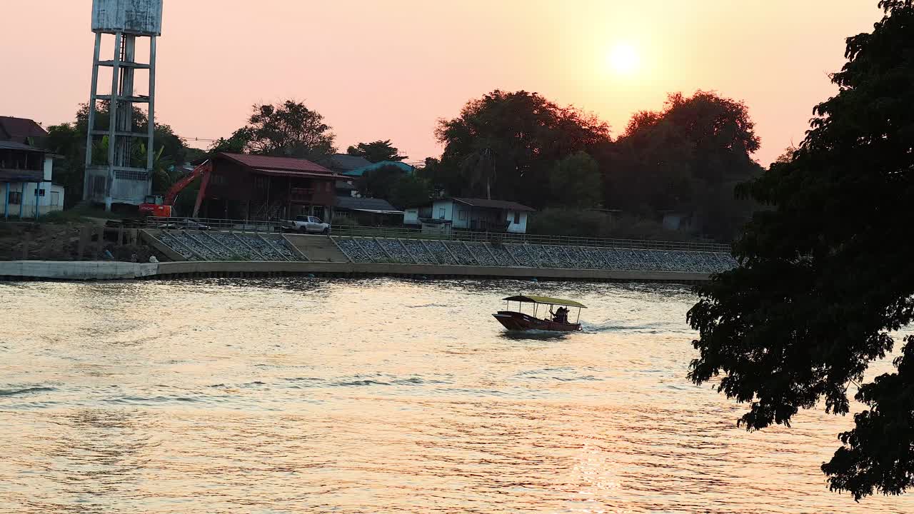 한 배가 해가 지면 강을 가로질러 움직인다