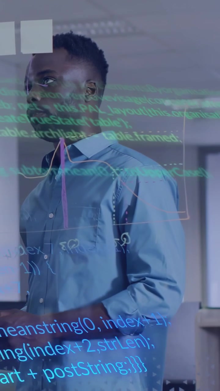 Vertical video: Man reviewing code and gesturing in tech office, causing code scrolling on glass