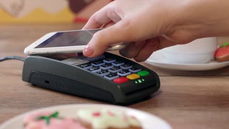 Pago-Móvil-NFC-Para-Pedidos-En-Cafetería.-Cliente-Pagando-A-Través-Del-Teléfono-Móvil