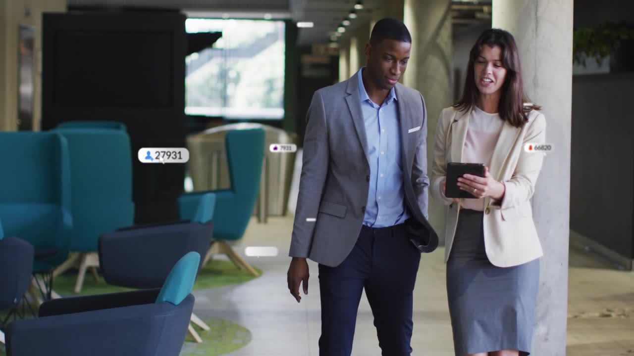 Man pointing phone and woman tapping tablet in business lobby, tracking alerts growing around them