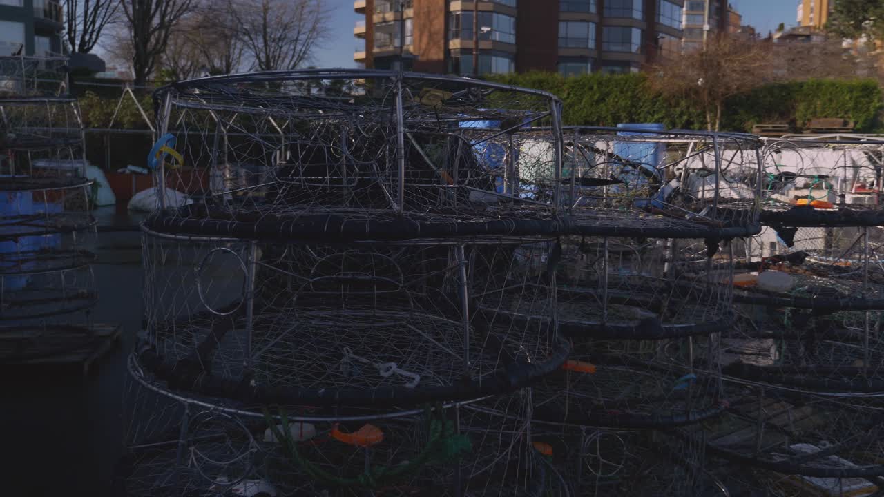 A medium close-up of crab fishing cages piled up at the fishing dock ready for use during the crabbing harvesting season lobster seafood industry