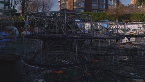 a medium close-up of crab fishing cages piled up at the fishing dock ready for use during the crabbing harvesting season lobster seafood industry