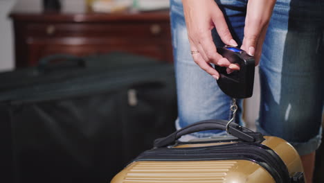 una mujer entiende y pesa su equipaje antes de salir del hotel