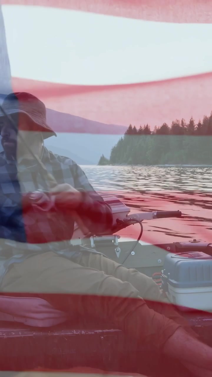 Video verticale: Uomo in barca che controlla la lenza, regolando il mulinello per la pesca, con bandiera americana sovrapposta all'uomo