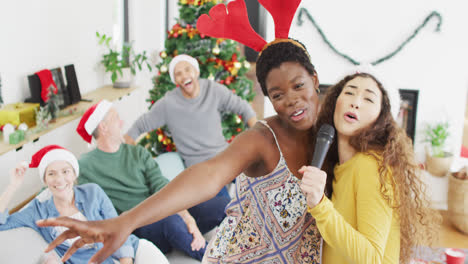 un grupo feliz de amigos diversos cantando karaoke en una fiesta de navidad