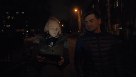 hombre y mujer hablando mientras caminan en la noche de invierno
