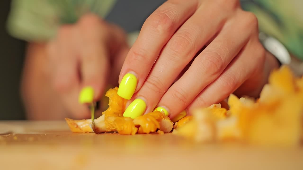 Sunset glow reveals bright nails slicing mushroom in close tactile gesture