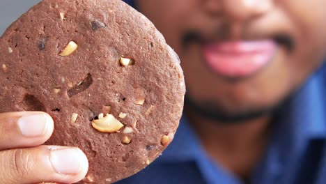 person eating a chocolate chip cookie