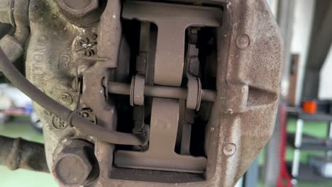 primer plano lateral de pinzas de freno desgastadas y pastillas de freno en la parte trasera del lexus ls 430