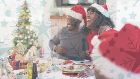 animation of snow falling over smiling family with santa hats having dinner