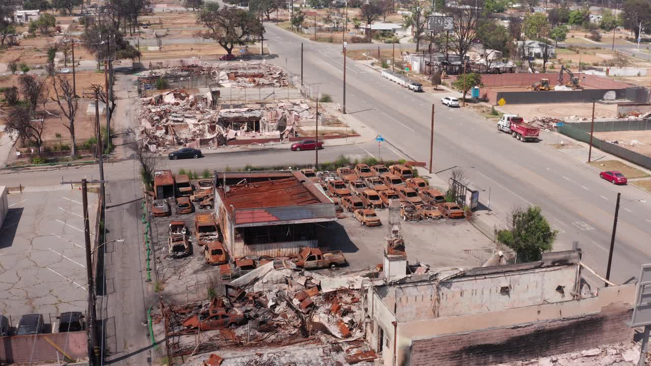 Aerial descending close-up shot of burned cars at the Altadena Auto Center on Fair Oaks Ave. after the Eaton Fire in Southern California. 4K