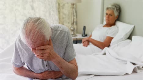 upset senior couple arguing with each other in bedroom