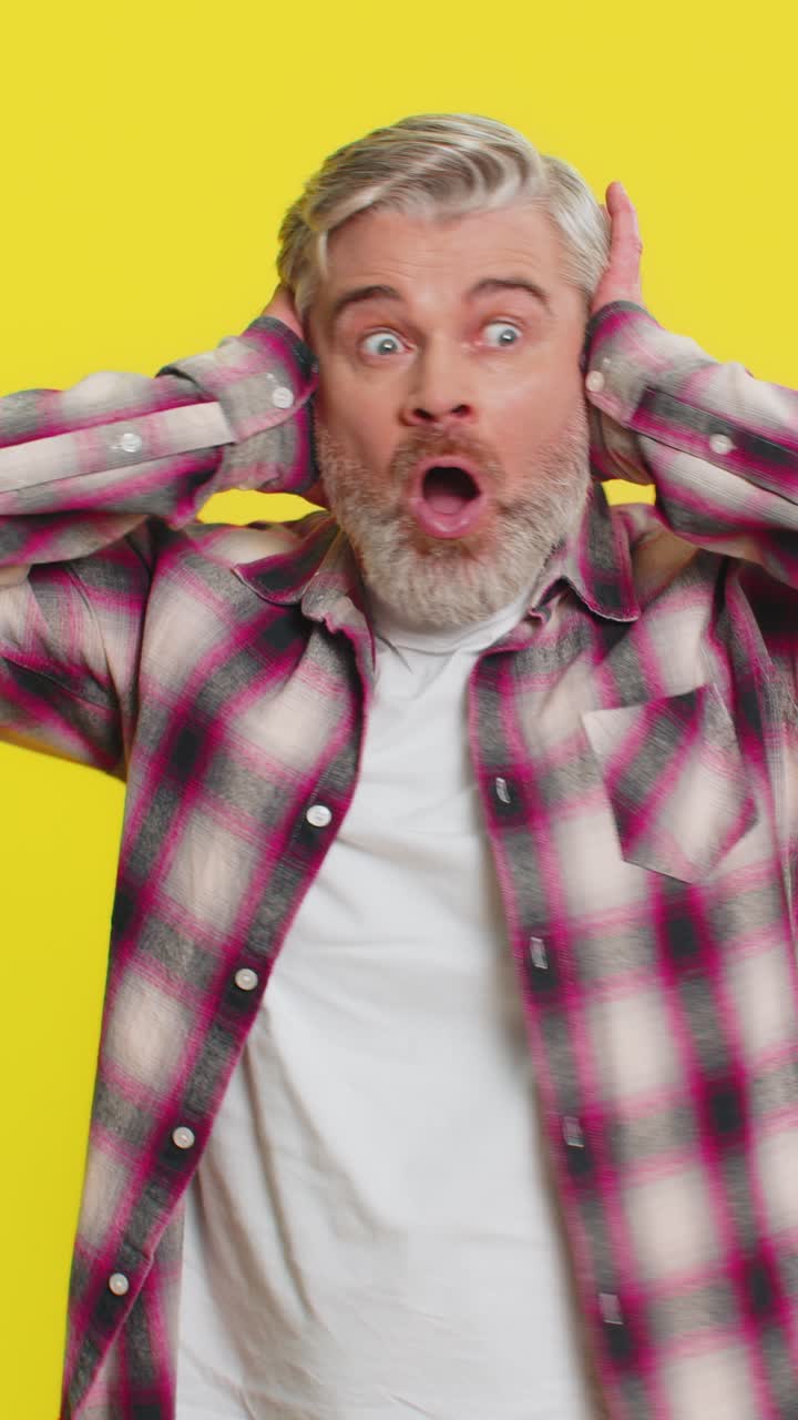 Mature man covering ears intense fear gesture startled panic from loud noise shocking reaction