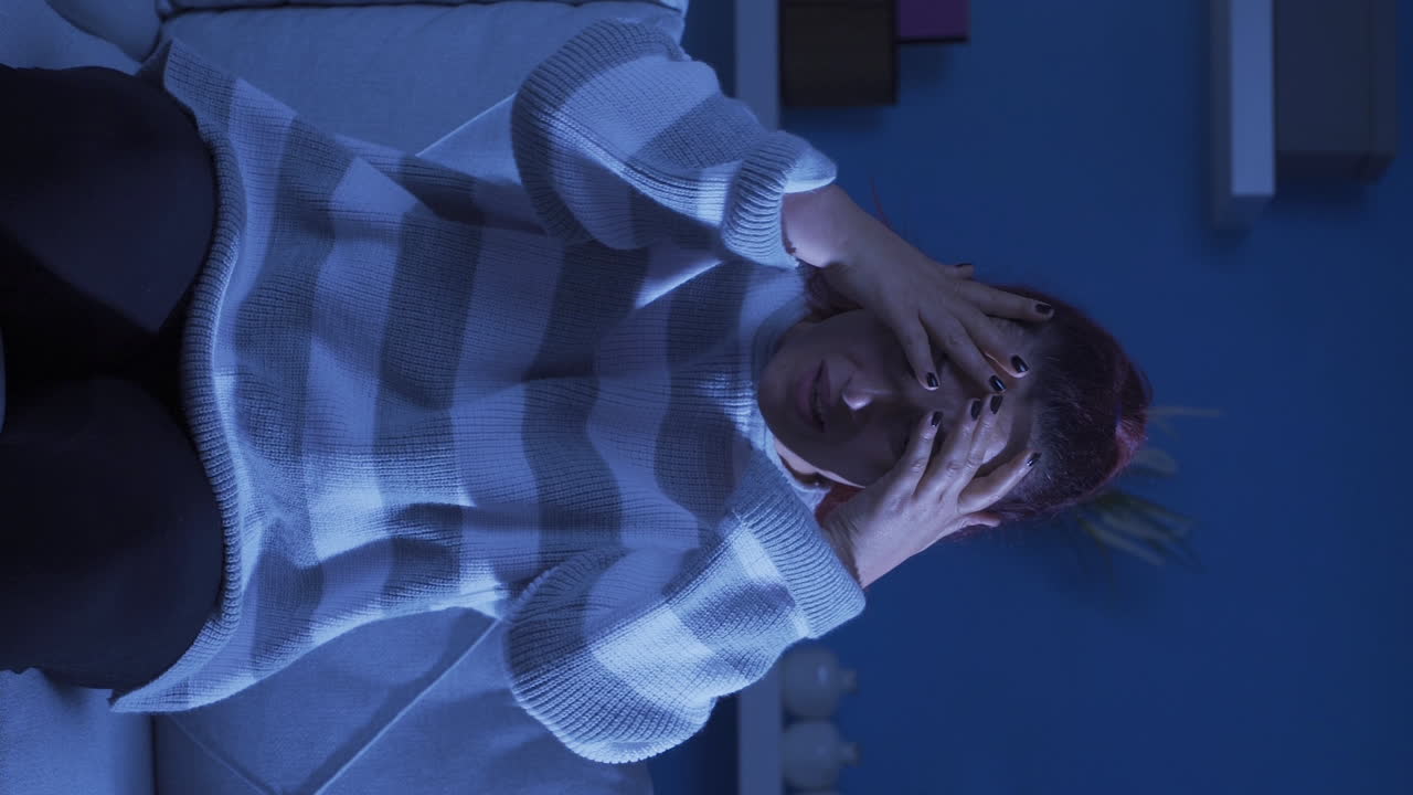 vídeo vertical de una mujer triste llorando en casa.