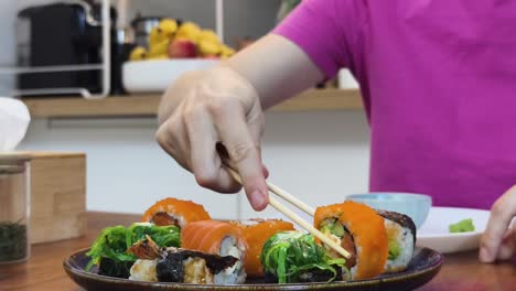 persona comiendo sushi en la cocina