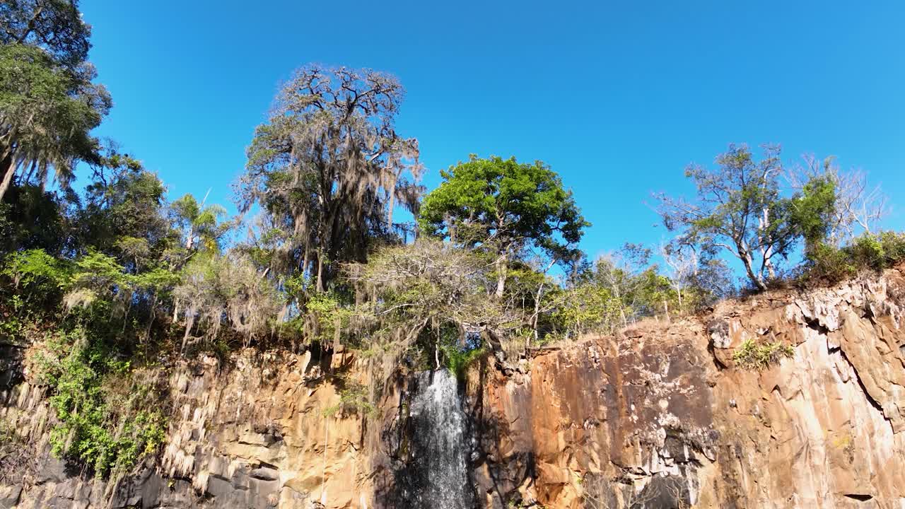 Waterfall at scenic gorge canyon. Peaking waterfall landscape. Nature background. Waterfalls cascade at gorge canyons background. Geologycal formation ecosystem. Waterfalls landscape