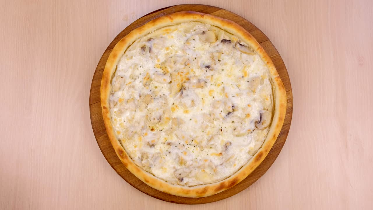 pizza con setas champignons y queso en tabla de madera en la mesa.