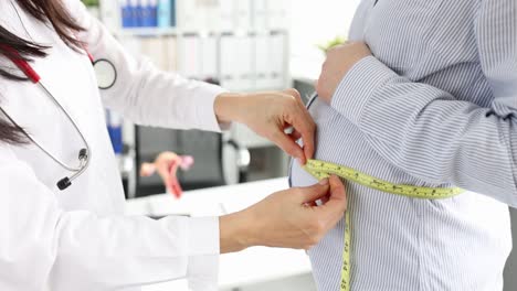 Doctor measuring pregnant woman's belly during a check-up