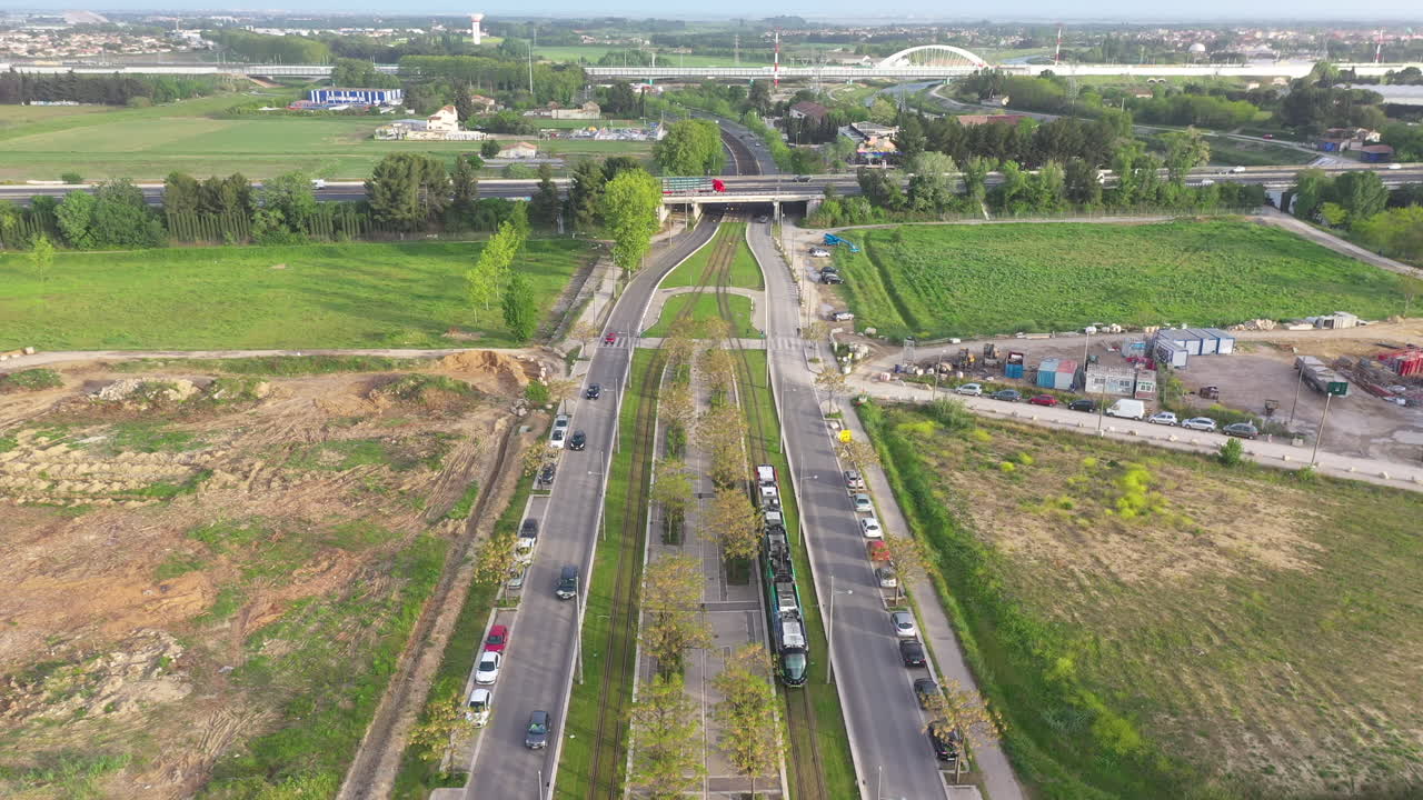 tomada aérea del tranvía pasando bajo un puente montpellier puerto marianne puesta de sol