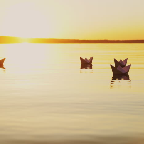 yellow rays of the evening sun shining on the paper boats swimming in the river at sunset. origami ships reflects in the water outdoors