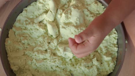 child playing with green kinetic sand