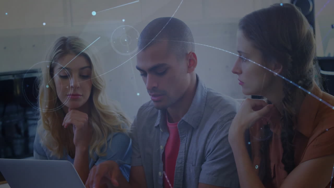 Three colleagues analyzing laptop with holographic charts during technology brainstorming meeting