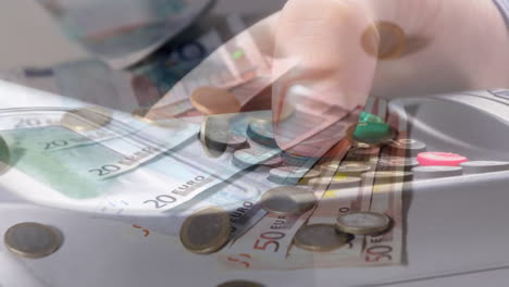 animación de billetes y monedas de euro que caen sobre la mano de un hombre caucásico que tiene una terminal de pago