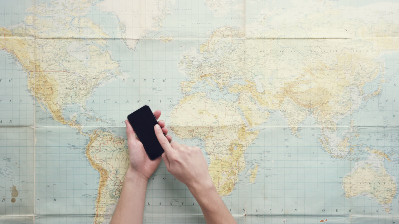 vista superior manos usando teléfono móvil pantalla táctil digital navegando mapa mundial mundial trabajando en el escritorio desde arriba - dragón épico rojo