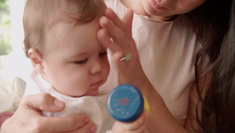 madre y bebé jugando con juguetes coloridos en casa