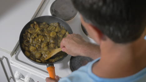 man cooking stewed vegetables at home