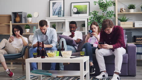 friends relaxing at home watching tv with phones